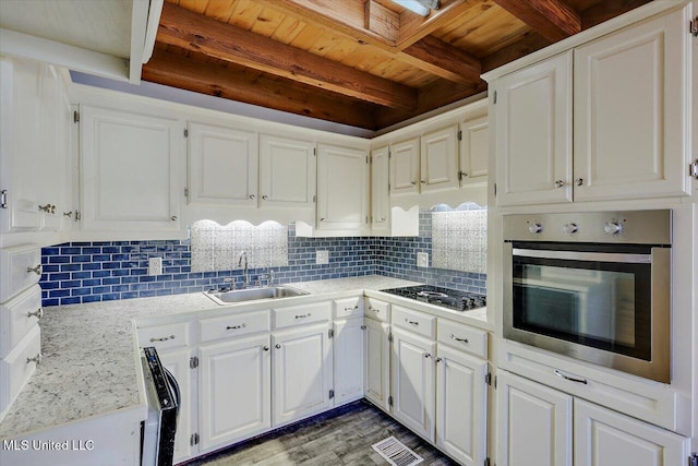 kitchen featuring decorative backsplash, white cabinetry, and oven