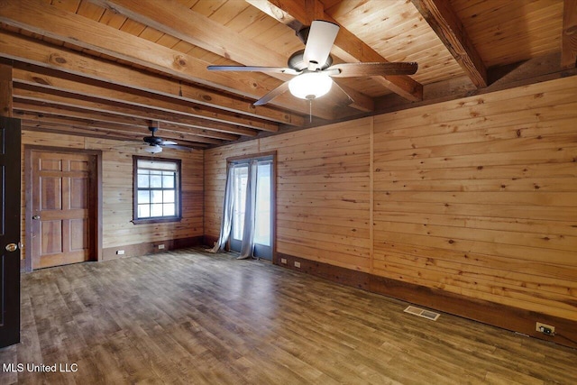 unfurnished room with ceiling fan, beam ceiling, wooden ceiling, and wooden walls