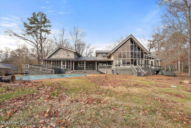 rear view of property with a swimming pool side deck and a sunroom