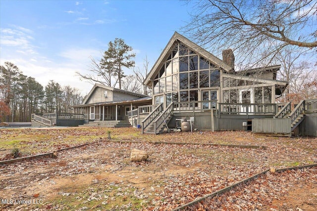 back of house featuring a sunroom and a deck