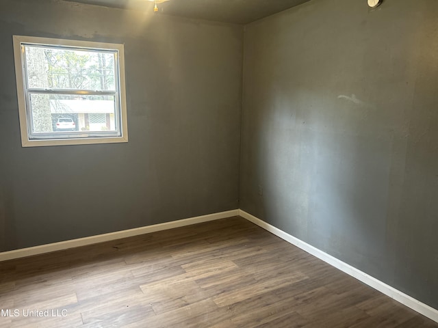 empty room featuring baseboards and wood finished floors