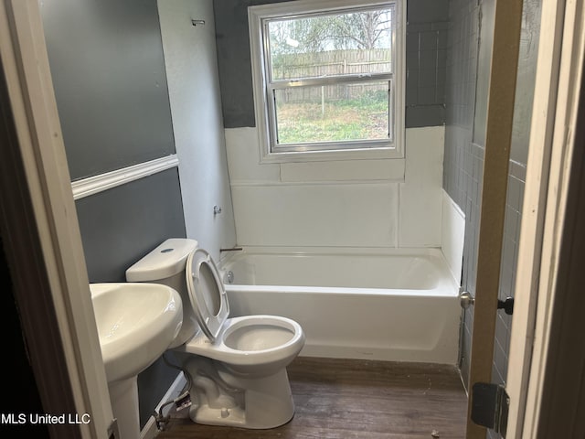 bathroom featuring toilet, tub / shower combination, and wood finished floors