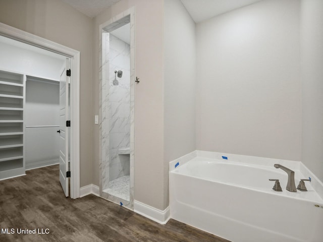 130 Everly Cir, Ocean Springs, MS 39564 - bathroom with a garden tub, wood finished floors, baseboards, a marble finish shower, and a walk in closet
