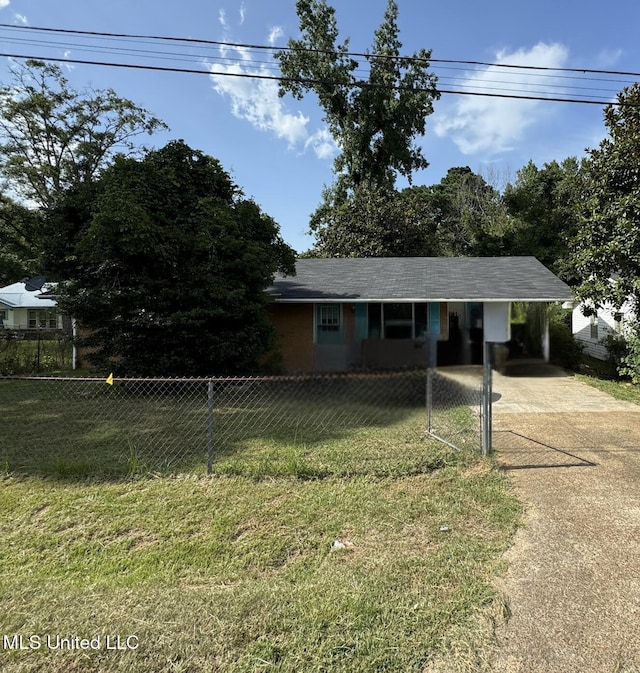 view of front of home with a carport, concrete driveway, a front lawn, and a fenced front yard