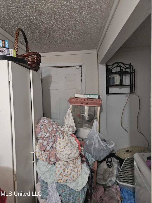 8800 Graham Rd, Moss Point, MS 39562 - bedroom featuring freestanding refrigerator and a textured ceiling