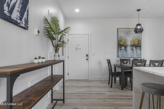 dining area with light wood finished floors and recessed lighting