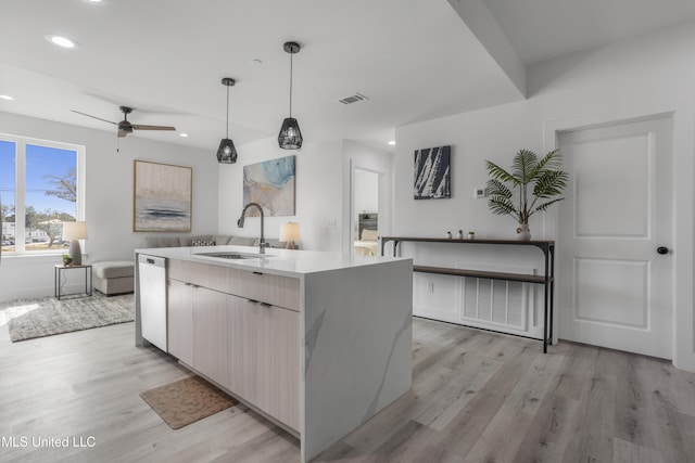 kitchen featuring dishwasher, light wood-style flooring, a sink, and visible vents