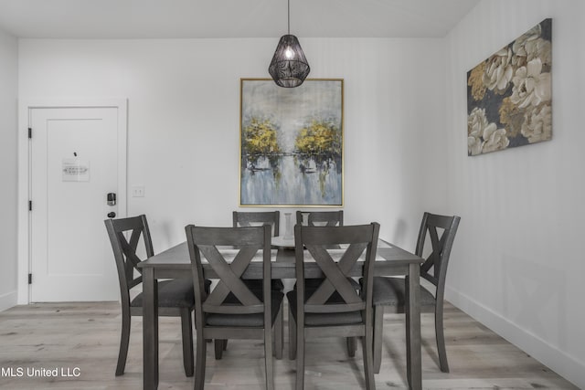 dining area with light wood-style floors and baseboards