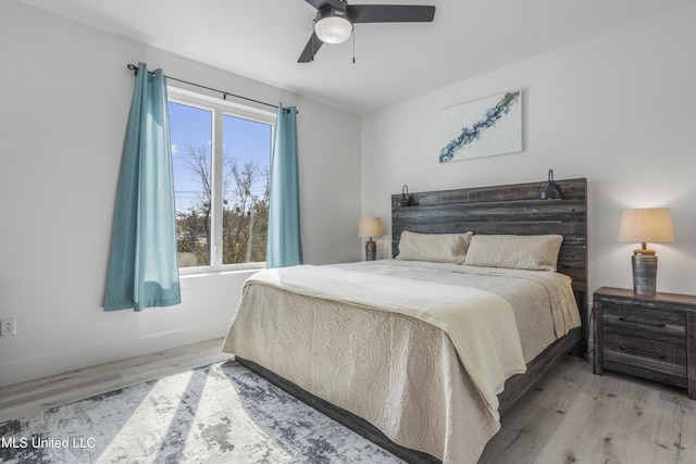 bedroom with a ceiling fan, baseboards, and wood finished floors