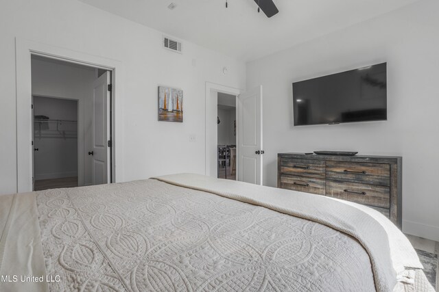 bedroom featuring a ceiling fan, visible vents, a spacious closet, and baseboards