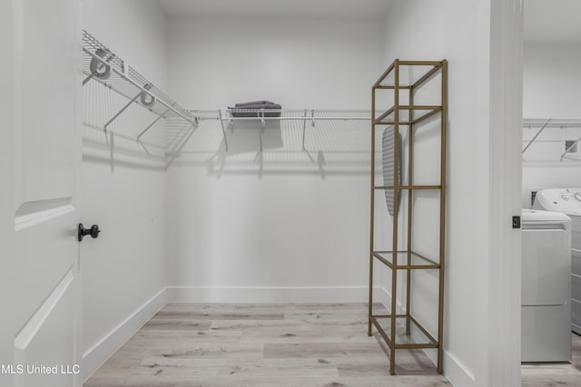 spacious closet with independent washer and dryer and light wood-style flooring