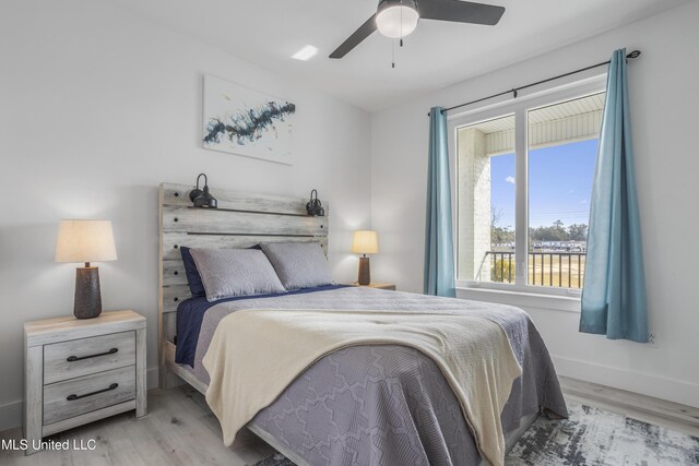 bedroom with wood finished floors, a ceiling fan, and baseboards