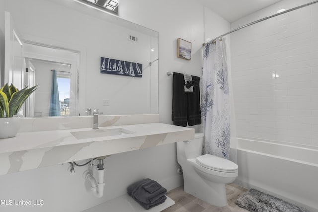 bathroom with shower / tub combo, visible vents, a sink, and toilet