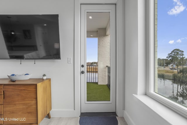 doorway to outside with light wood-style flooring and baseboards