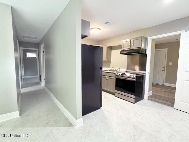 kitchen featuring gray cabinetry, stainless steel range oven, sink, and black fridge