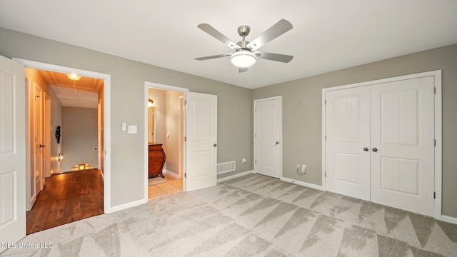 unfurnished bedroom with attic access, carpet flooring, baseboards, and ensuite bath