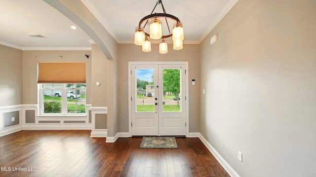 entryway with a chandelier, dark wood-style flooring, arched walkways, and ornamental molding