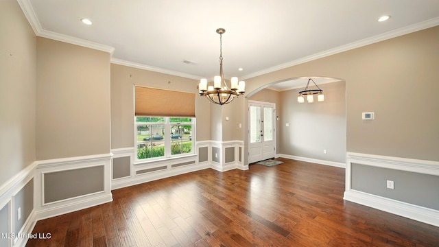 empty room featuring a chandelier, arched walkways, wood finished floors, ornamental molding, and recessed lighting