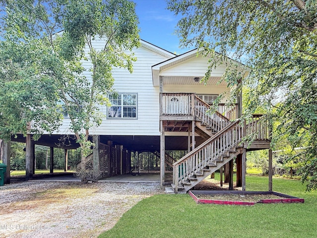 7011-13 W Marion St, Bay Saint Louis, MS 39520 - rear view of property featuring driveway, stairway, a carport, and a yard
