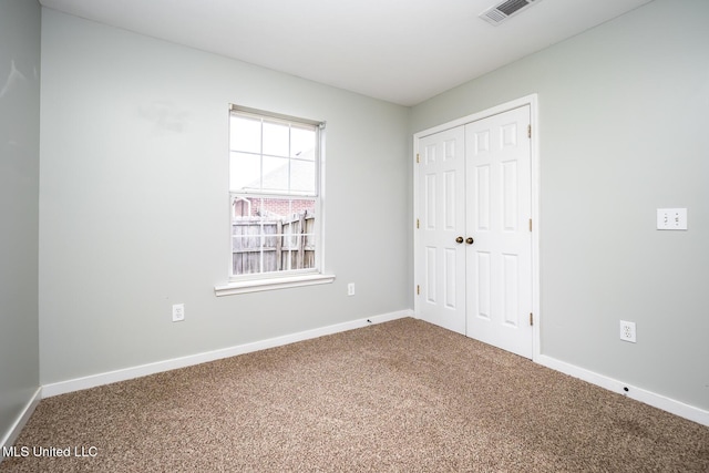 unfurnished bedroom featuring carpet floors and a closet