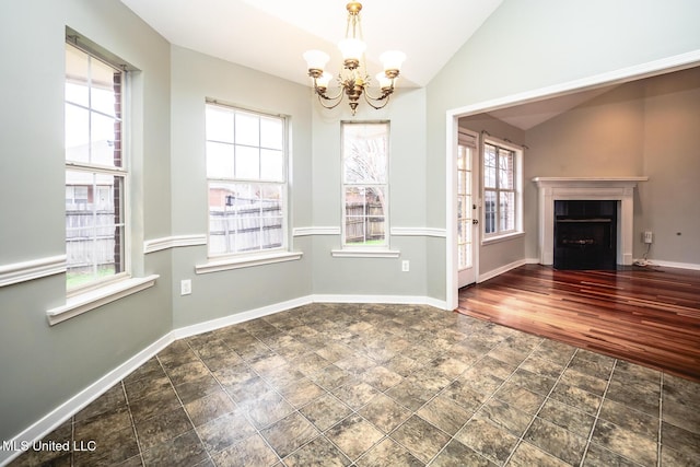 unfurnished dining area featuring plenty of natural light, a chandelier, and lofted ceiling