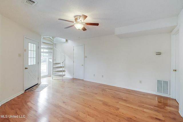 unfurnished living room with light wood-type flooring and ceiling fan