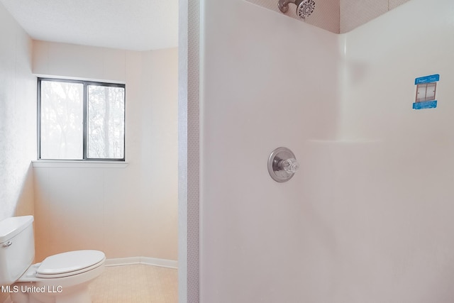 bathroom featuring walk in shower and toilet