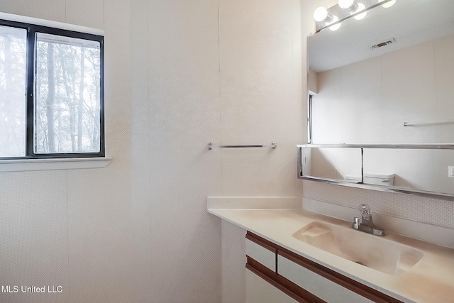 bathroom with vanity, plenty of natural light, and toilet