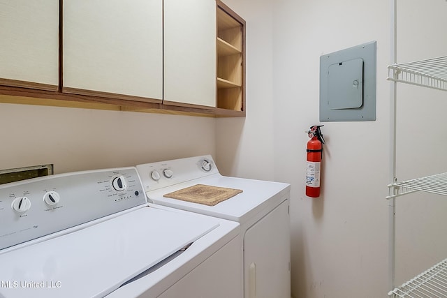 washroom with electric panel, cabinets, and washer and clothes dryer