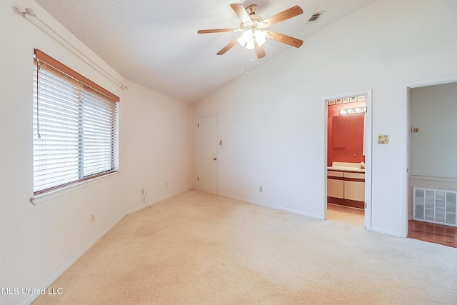 unfurnished room featuring lofted ceiling, light carpet, and ceiling fan