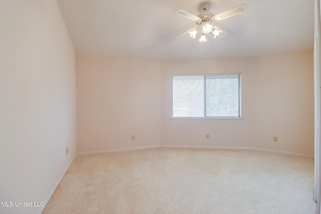 carpeted spare room featuring ceiling fan