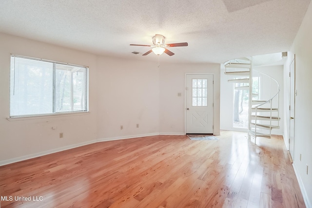 interior space with light hardwood / wood-style floors, ceiling fan, and a textured ceiling