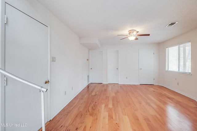 spare room with ceiling fan and light wood-type flooring