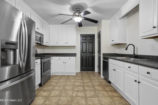 kitchen featuring white cabinets, ceiling fan, dark countertops, a sink, and stainless steel appliances