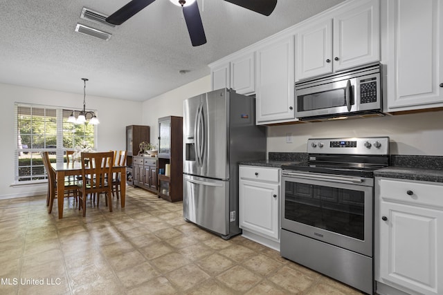 kitchen with dark countertops, a textured ceiling, white cabinetry, ceiling fan with notable chandelier, and stainless steel appliances