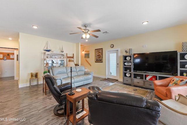 living room featuring hardwood / wood-style floors and ceiling fan