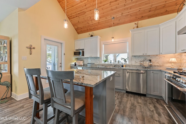 kitchen featuring sink, dark hardwood / wood-style flooring, stainless steel appliances, wooden ceiling, and decorative light fixtures