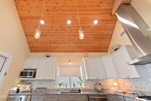 kitchen with stainless steel appliances, sink, pendant lighting, white cabinetry, and high vaulted ceiling