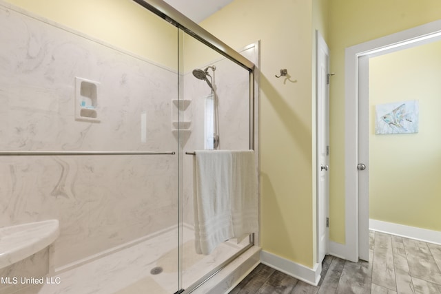 bathroom with wood-type flooring and an enclosed shower