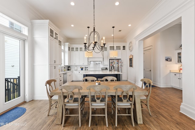 dining space featuring crown molding, wood-type flooring, and a wealth of natural light