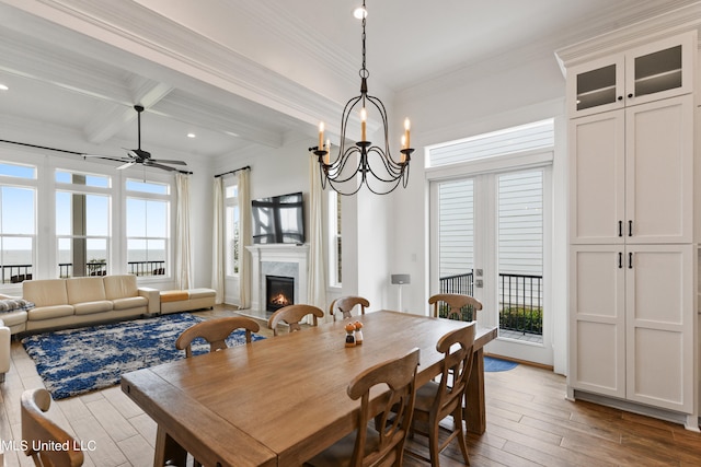 dining area with hardwood / wood-style floors, ornamental molding, coffered ceiling, a premium fireplace, and beam ceiling