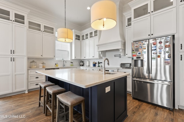 kitchen featuring white cabinetry, stainless steel appliances, sink, and a center island with sink