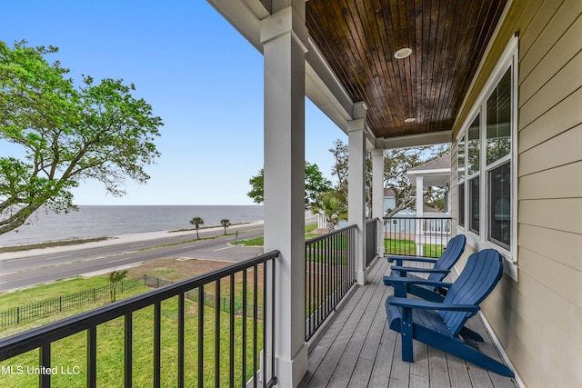 balcony featuring covered porch and a water view