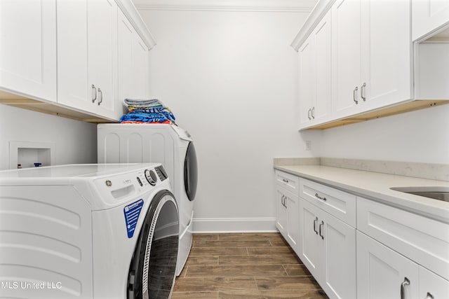 laundry room featuring separate washer and dryer, dark hardwood / wood-style flooring, and cabinets