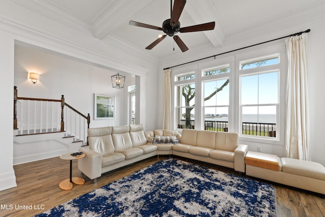 living room with dark wood-type flooring, beam ceiling, a water view, coffered ceiling, and ornamental molding