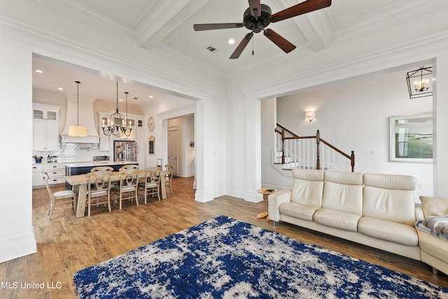 living room with hardwood / wood-style flooring, ornamental molding, and beamed ceiling