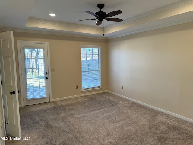 unfurnished room with baseboards, a tray ceiling, carpet flooring, and ornamental molding