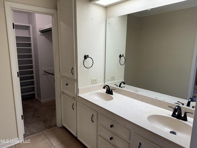 full bathroom with a spacious closet, tile patterned flooring, and a sink