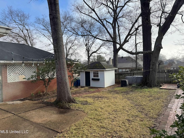 view of yard with an outdoor structure, fence, and cooling unit