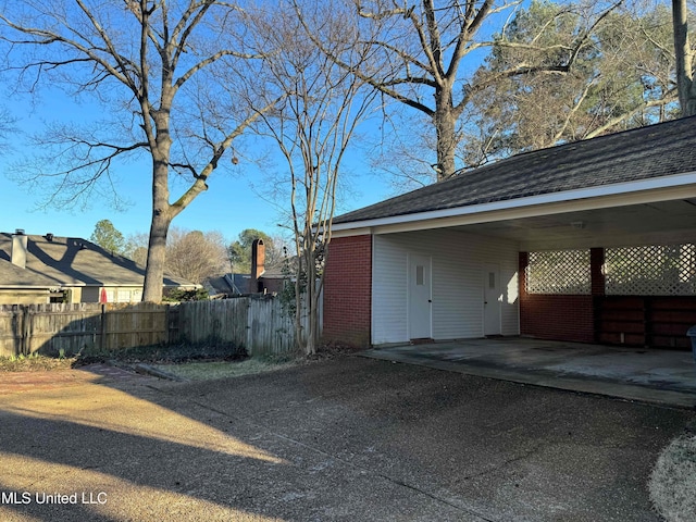 exterior space featuring an attached carport and fence